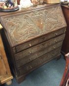 A good oak carved bureau with four tapering drawer