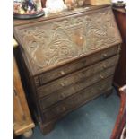 A good oak carved bureau with four tapering drawer