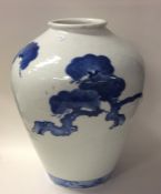 A tall blue and white tapering Eastern vase decora