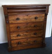 A flame mahogany chest of five drawers with turned