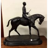 A tall bronze figure of a horse and rider on oval