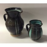 MILLAND POTTERY: Two similar pottery jugs in black