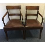 A pair of Georgian mahogany elbow chairs on tapere