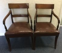 A pair of Georgian mahogany elbow chairs on tapere