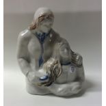 A pottery figure of a couple in natural glaze. App