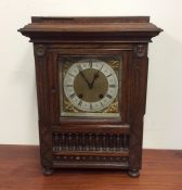 An oak cased mantle clock with silvered dial. Est.