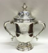 A large George II silver cup and cover on sweeping