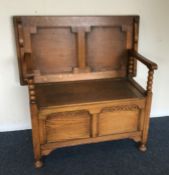 An oak hinged top settle with shaped decoration. E