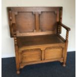 An oak hinged top settle with shaped decoration. E