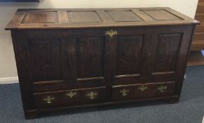 A large oak mule chest with hinged lid and brass h