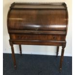 A reproduction cylinder top bureau on fluted suppo