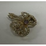 An amethyst and pearl 15 carat bow brooch with mat