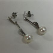 A pair of pearl and diamond drop earrings set in w