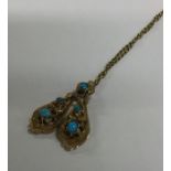 A small gold and turquoise pendant on fine link ch