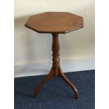 A octagonal pedestal table on three sweeping suppo