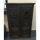 A Continental oak carved cupboard with pierced fre