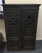 A Continental oak carved cupboard with pierced fre