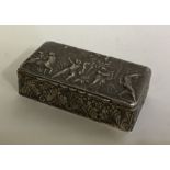 A silver embossed top box decorated with figures.