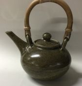 A small ovoid shaped lidded teapot with olive gree