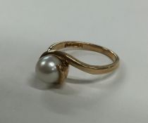 A pearl single stone crossover ring in 9 carat. Ap