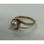 A pearl single stone crossover ring in 9 carat. Ap