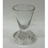 A heavy Georgian tapering glass on circular spread