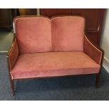 A pink upholstered and inlaid two seater settee. E