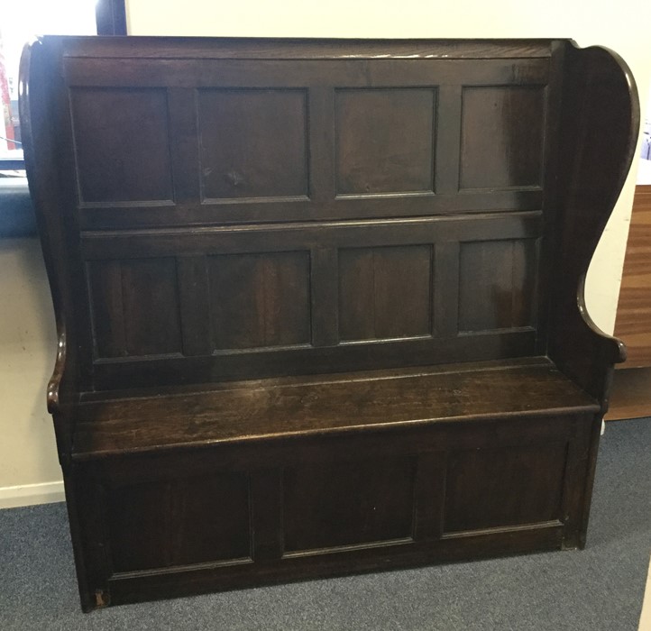 A good oak panelled settle with hinged seat to sha