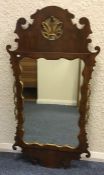 A gilt and mahogany wall mirror. Est. £30 - £50.