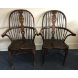 A pair of oak Windsor chairs on curved stretcher b