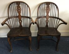 A pair of oak Windsor chairs on curved stretcher b