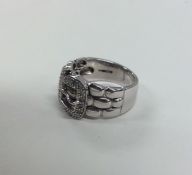 A large diamond buckle shaped ring in white gold.