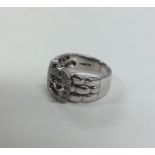 A large diamond buckle shaped ring in white gold.