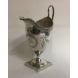 A George III engraved silver cream jug decorated w