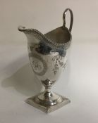 A George III engraved silver cream jug decorated w