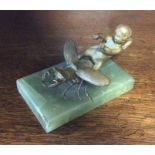 A bronzed figure of a child on onyx rectangular ba