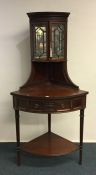 An Edwardian mahogany corner cabinet with bevelled