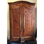 A large fruit wood armoire with shaped top and bra