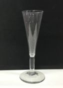 A tall tapering Georgian wine glass on sweeping pe