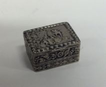 A small hinged top silver pill box decorated with