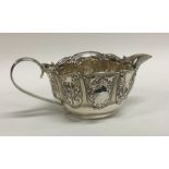 CHESTER: An oval chased silver cream jug with shap