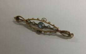 A pearl and blue stone brooch mounted in 15 carat