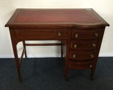 An Edwardian mahogany kidney shaped desk with cros