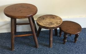 Three small milking stools. Est. £10 - £20.