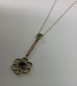 SUFFRAGETTE: A small Edwardian gold pendant on fin