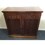 A mahogany two door side cabinet with scroll decor