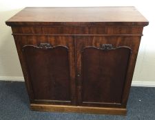 A mahogany two door side cabinet with scroll decor