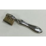 A novelty silver toothbrush with shaped handle. Bi
