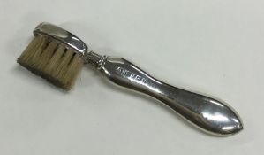 A novelty silver toothbrush with shaped handle. Bi