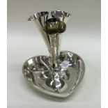 A decorative silver heart shaped three trumpet epe